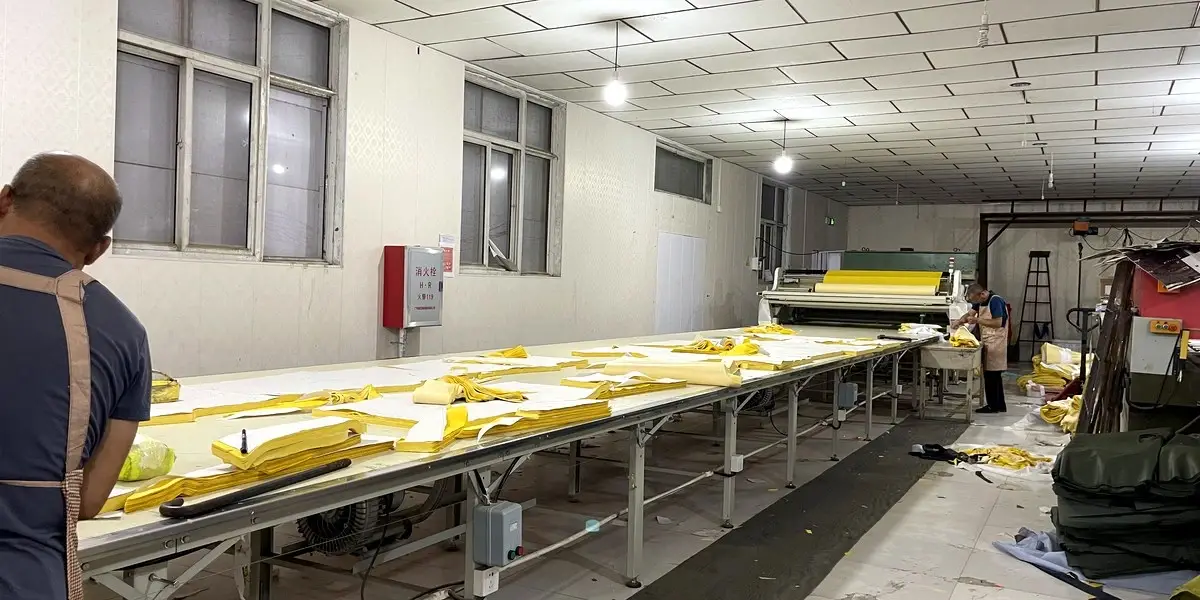 Fabric cutting table with cut pattern pieces at PURAINGEAR factory